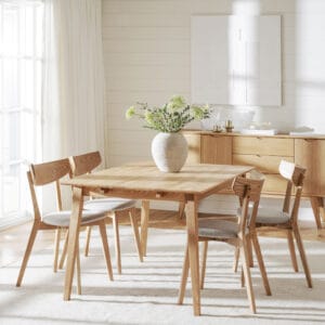 Rowico jatkettava Filippa-ruokapöytä. Miljöökuvassa tammen värinen pöytä Ami-tuolien kanssa valoisassa, vaaleansävyisessä huoneessa.