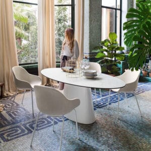 Connubia Ellisse-ruokapöytä, ovaali. Miljöökuvassa valoisa ruokailutila, jossa nainen katselee ikkunasta ulos.