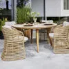 Cane-line Basket-ulkotuoli Weave-polyrottingista, vaalea tuoli, jossa taupen sävyinen pehmuste. Miljöökuvassa Aspect-pöydän kanssa.