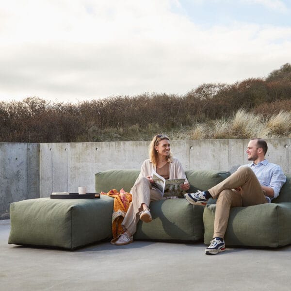 SACKit Soft Sofa ulkosohvan divaani, vihreä (olive). Miljöökuvassa mies ja nainen istuvat divaanisohvalla.