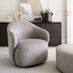 Rowico Chapeltown-nojatuoli, pyörimistoiminto. Tumma beige Brenda-kangas. Miljöökuvassa tuoli olohuonemiljöössä, taustalla ruskea Melstone-senkki.