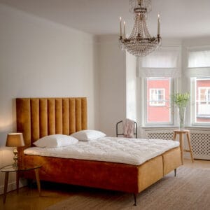 Dorbien Nature-runkopatjasänky. Miljöökuvassa sänky oranssinruskealla kankaalla.